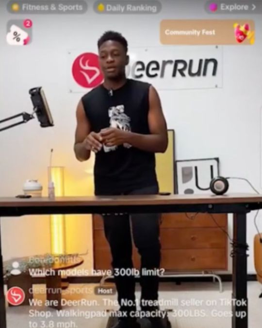 A man running a TikTok Live, demonstrating the miniature treadmill he is selling while commenters ask questions about the product