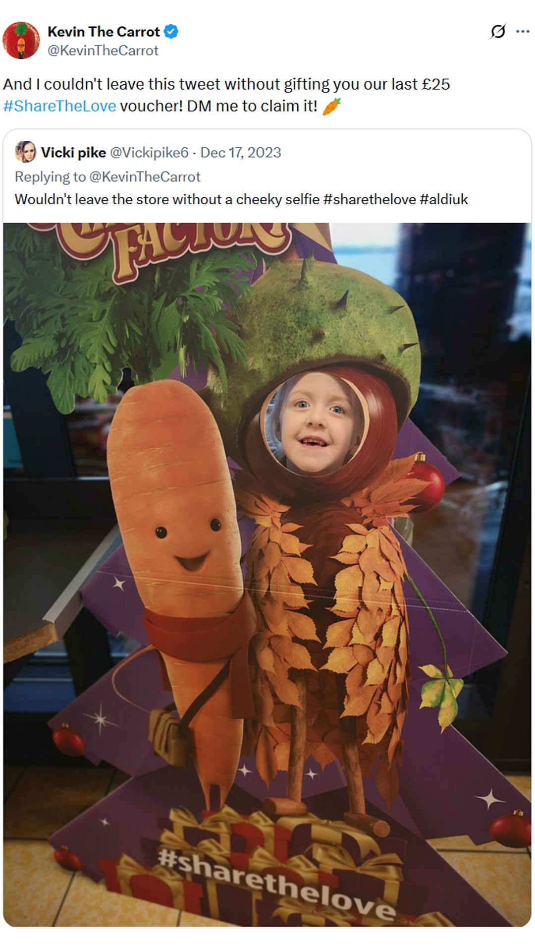 Shopper with head through Kevin the Carrot photo board holding cartoon carrot body.