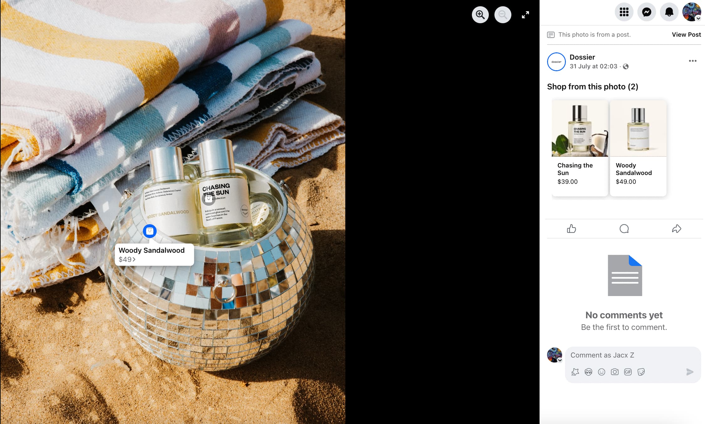 Two bottles of Dossier perfumes placed inside a disco ball on a sandy surface alongisde some striped towels