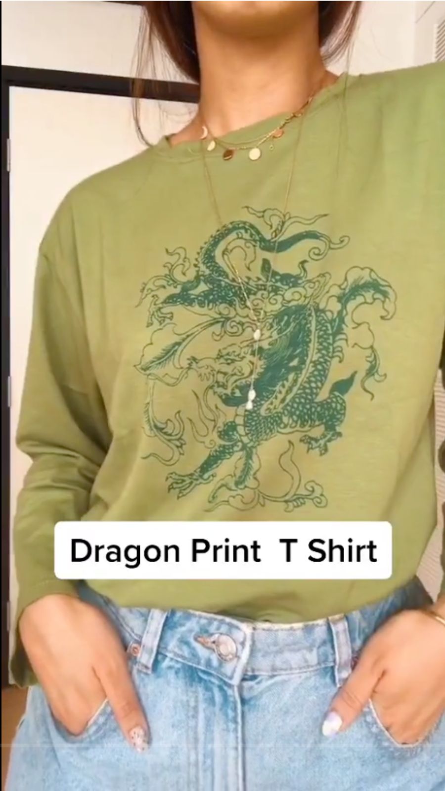 A TikToker tries on a dragon print t-shirt.