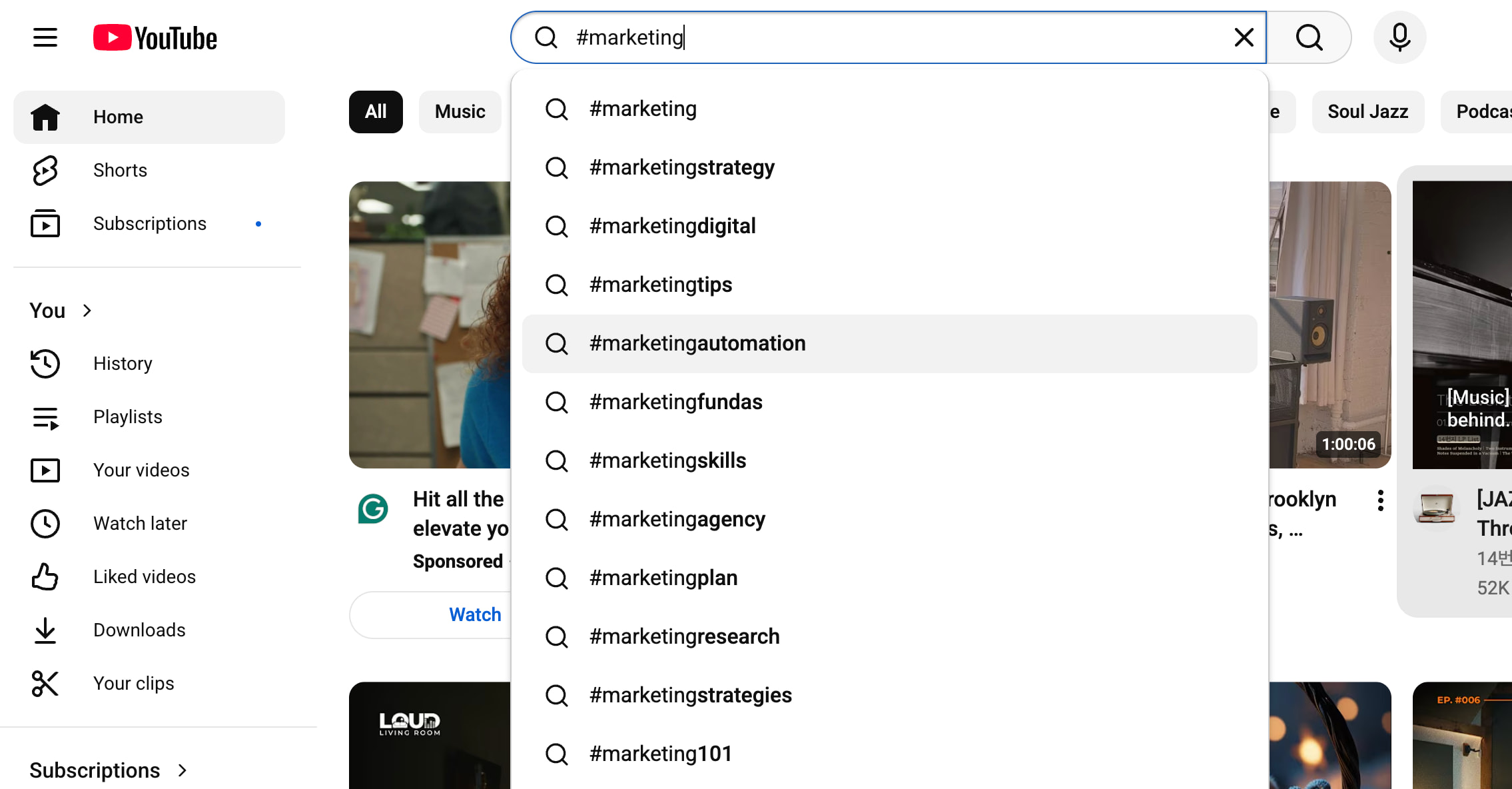 UI screen of YouTube search bar with "#marketing" typed in to show the autosuggest searches pop up