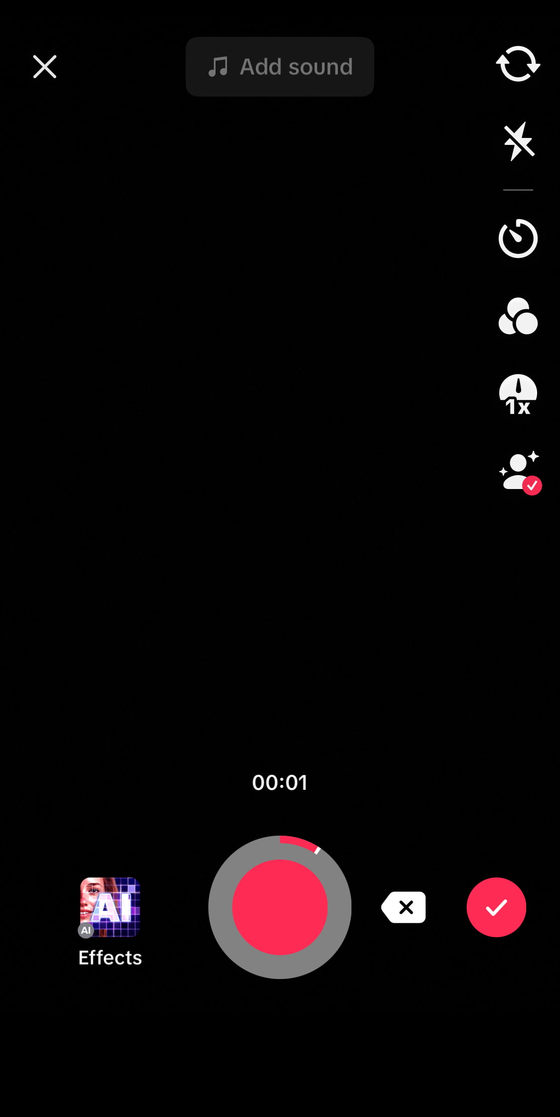 A black screen of the TikTok interface showing a red record button to capture or upload a video.