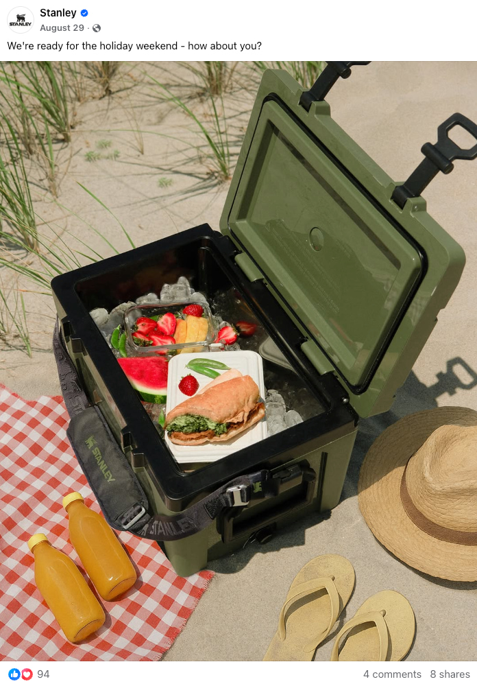 Stanley's Facebook post shows an open cooler with food sitting on the sand and a beach blanket 