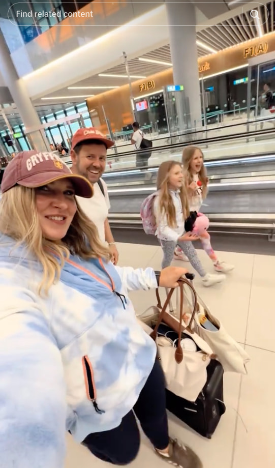 A snapshot of Here We Go Again features a smiling family of four as they walk through an airport terminal with luggage, heading toward their gate.