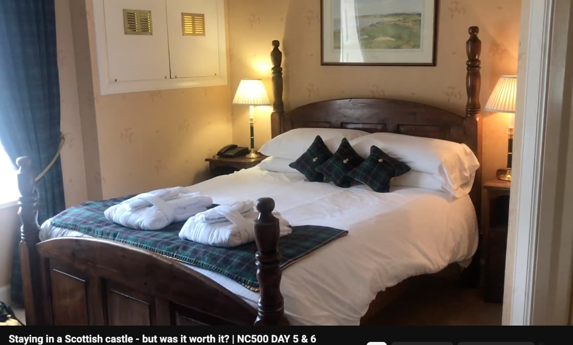A cosy bedroom inside a Scottish castle hotel, with tartan cushions, bathrobes and warm lighting.