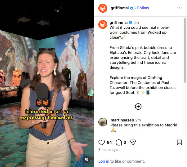 Woman with microphone tours "Crafting Character," an exhibit of movie-worn Wicked costumes including Glinda's pink gown.